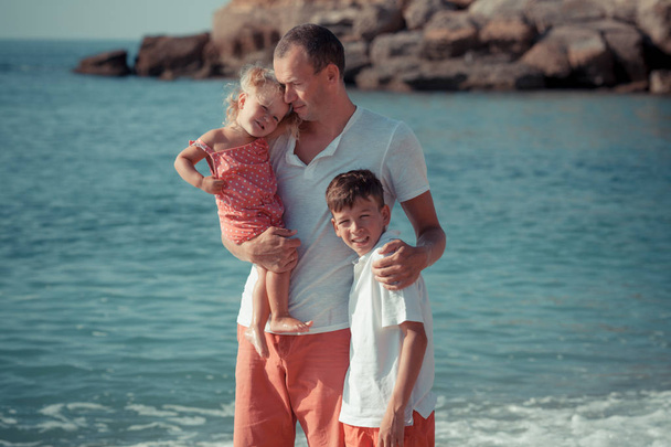 happy father and kids go along the seashore - Photo, image