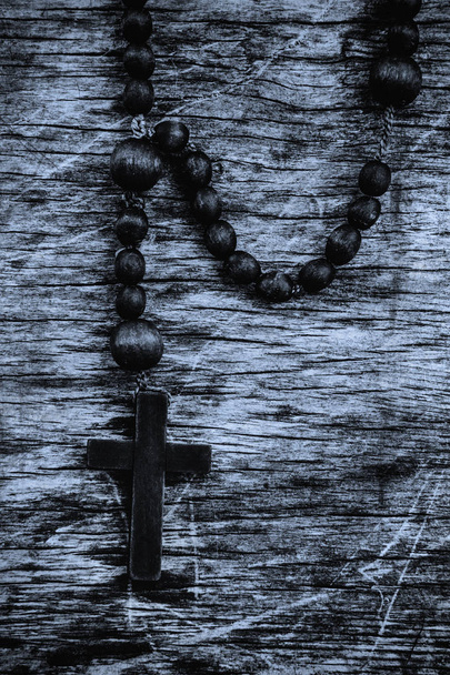 rosario de estilo retro sobre fondo de madera sucia. Simbolos de salvación, vida eterna y concepto de religión. - Foto, imagen