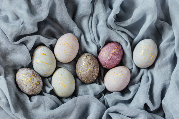 Stylish gray, violet and blue Easter eggs on color textile  - Fotoğraf, Görsel