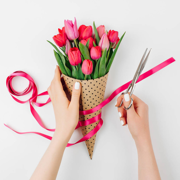 pink tulips with female florist hands on white background - Fotografie, Obrázek