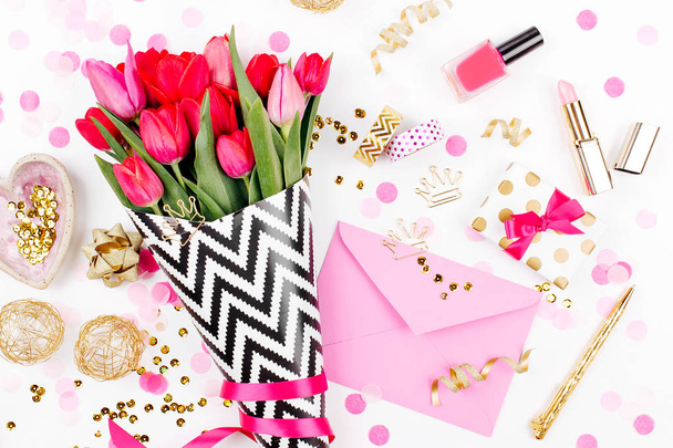 Pink tulips in black and white stylish wrapping paper, gifts, cosmetics and female accessories with confetti on white background - 写真・画像