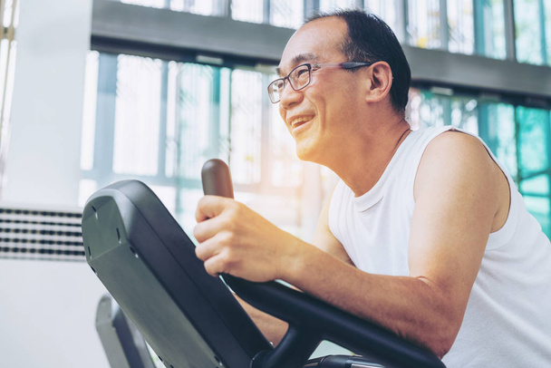 Senior man exercise on treadmill in fitness center. Mature healthy lifestyle. - Fotoğraf, Görsel