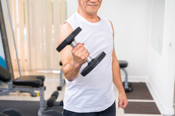 Starší muž zvedání činky v posilovně fitness. Vedoucí zdravý životní styl. - Fotografie, Obrázek