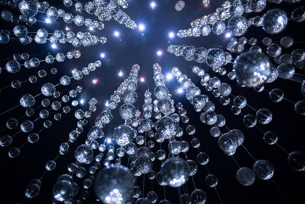 Transparent balls on line in bright light on dark blue background  - 写真・画像