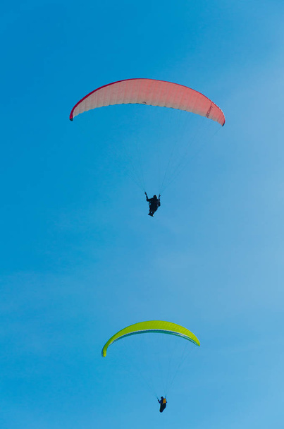 Paragliders flying in the blue sky at daytime  - Foto, Imagen