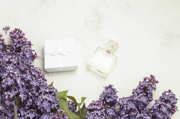 Flacon de parfum et coffret cadeau blanc, lilas sur fond de pierre claire
. - Photo, image