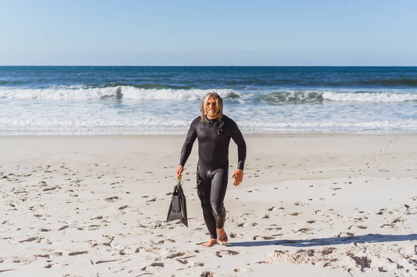 surfer with flippers on sandy beach  - Photo, image