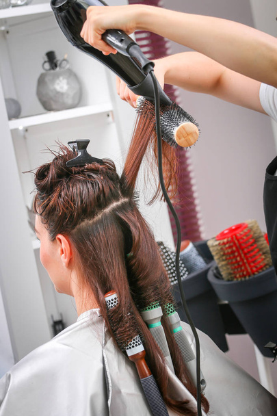 Dziewczyna w salonie piękności a stylista włosów wysuszyć włosy - Zdjęcie, obraz