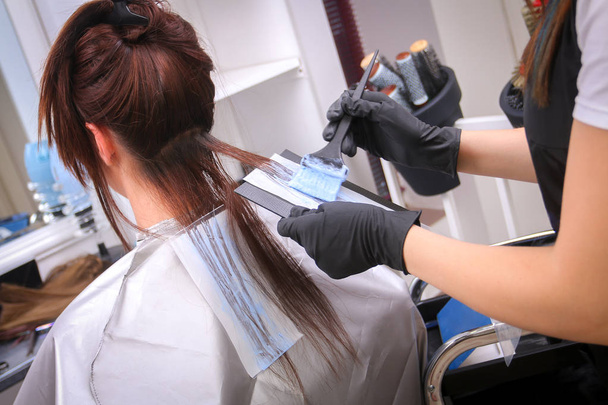 Meisje in de schoonheidssalon, terwijl een kapper die haar haren verven - Foto, afbeelding