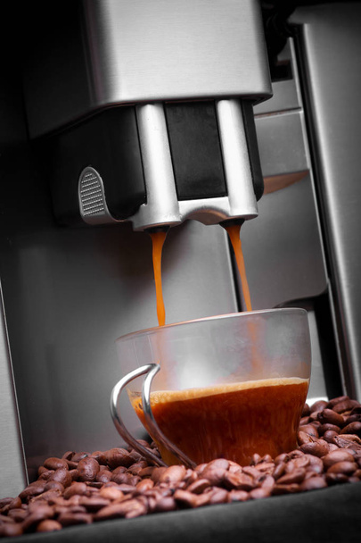 Еспресо-машина робить каву, кавові балки фоном
 - Фото, зображення