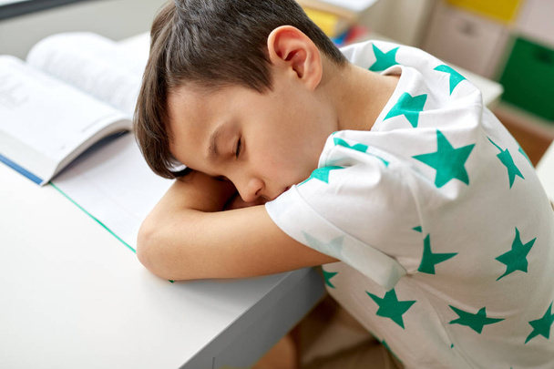 tired student boy sleeping on table at home - Foto, Bild
