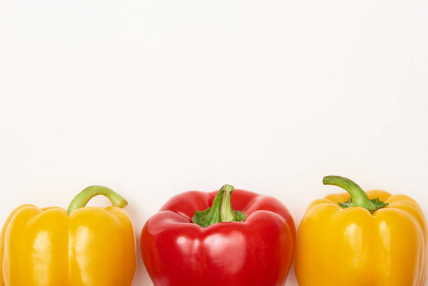 Studio shot of red and yellow bell peppers on white background - Foto, Imagem