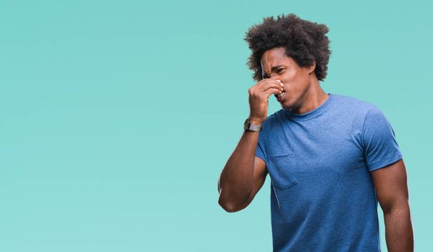 Afro-amerikai ember elszigetelt háttér szagú valami büdös és gusztustalan, elviselhetetlen szag, ujjaival, orr a gazdaság levegőt. Rossz szaga koncepció. - Fotó, kép