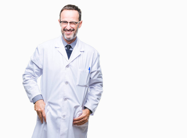 Middle age senior hoary professional man wearing white coat over isolated background winking looking at the camera with sexy expression, cheerful and happy face. - Foto, Imagen