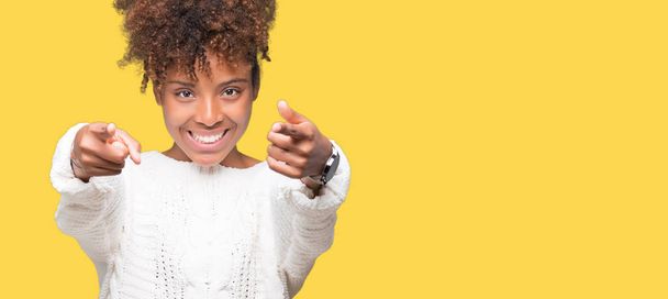 Güzel genç Afro-Amerikan kadın giyiyor kış kazak izole üzerinde arka plan size işaret ve parmaklar, olumlu ve neşeli gülümseyen kamerayla - Fotoğraf, Görsel