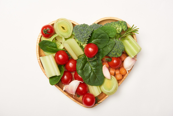 Top view of vegetables on heart shaped cutting board on white background - Photo, Image