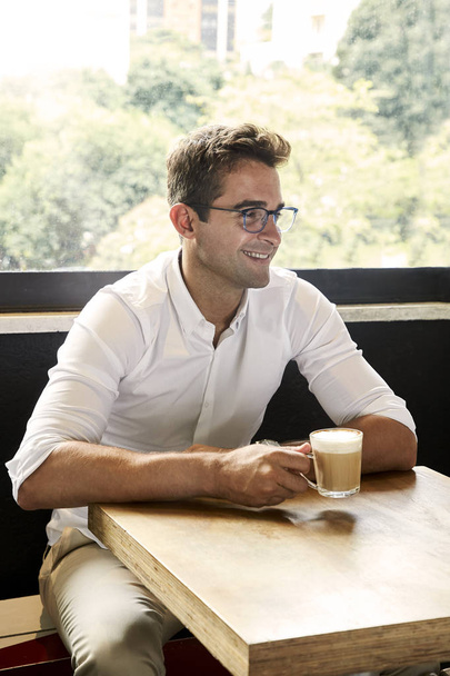 Smiling guy enjoying coffee in cafe - Zdjęcie, obraz