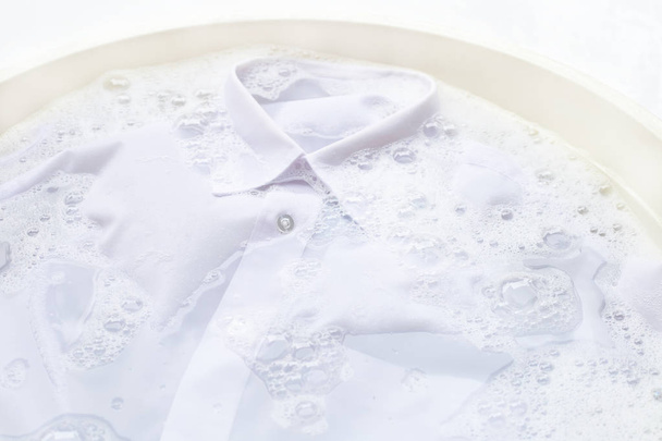vor dem Waschen ein Tuch einweichen, weißes Hemd - Foto, Bild