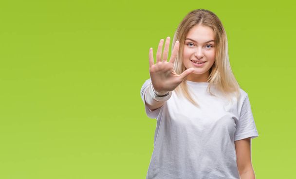 Jonge Kaukasische vrouw over geïsoleerde achtergrond weergeven en met de vingers omhoog nummer vijf terwijl lacht zelfverzekerd en blij. - Foto, afbeelding