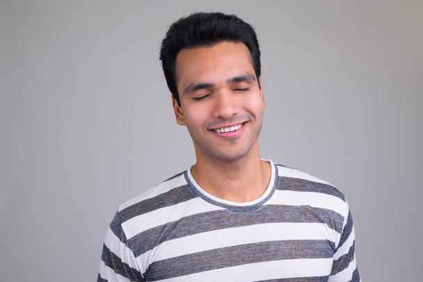 Muotokuva onnellinen nuori komea intialainen mies rentouttava silmät kiinni
 - Valokuva, kuva