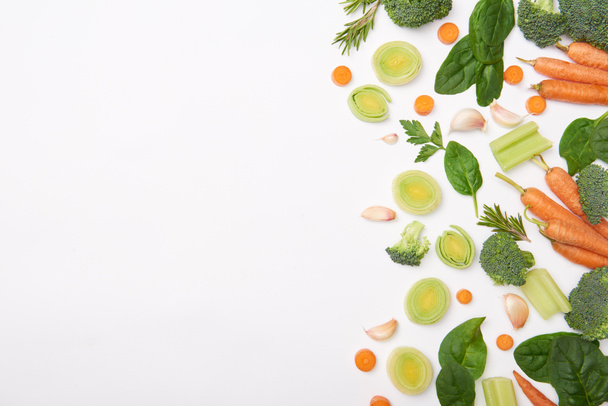 Vlakke leggen met natuurlijke groenten en spinazie bladeren geïsoleerd op wit - Foto, afbeelding