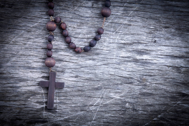 Cierre el rosario sobre fondo de madera como símbolo de salvación y vida eterna.. - Foto, imagen
