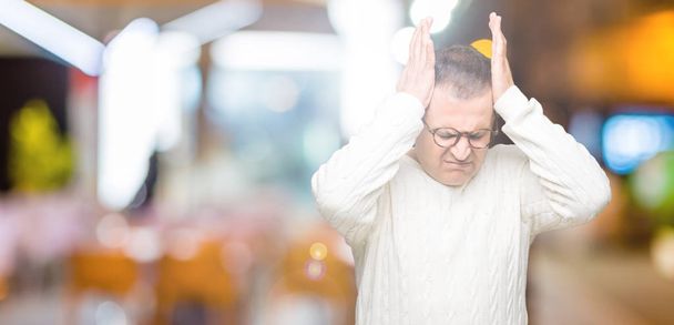 Middle age arab man wearing glasses over isolated background suffering from headache desperate and stressed because pain and migraine. Hands on head. - Фото, изображение