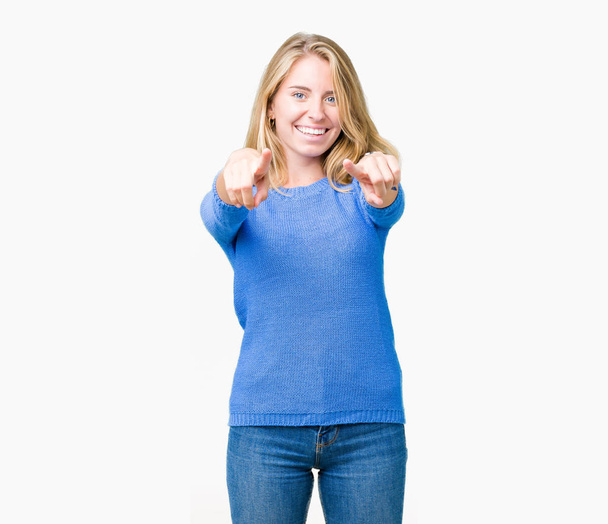 Belle jeune femme portant un pull bleu sur fond isolé Pointant vers vous et la caméra avec les doigts, souriant positif et joyeux
 - Photo, image