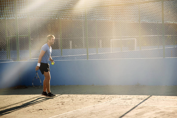 Sunlit tennis athlete on court - Zdjęcie, obraz
