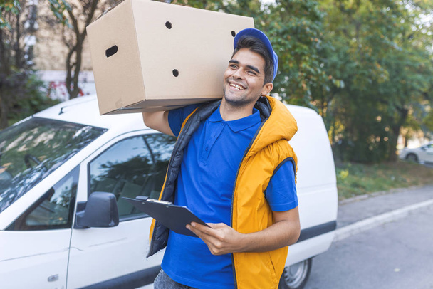 Portrait of courier with clipboard delivering package - Fotoğraf, Görsel