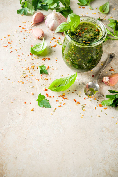 Argentinian traditional food, raw homemade green Chimichurri salsa or sauce woth parsley, garlic, basil leaves, hot pepper and spices, light stone table copy space  - Foto, Imagem