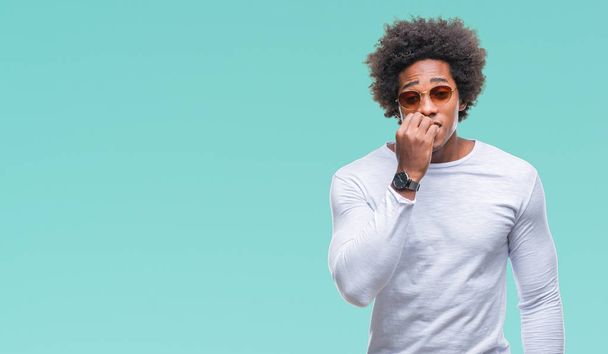 Afro american man wearing sunglasses over isolated background looking stressed and nervous with hands on mouth biting nails. Anxiety problem. - Фото, зображення