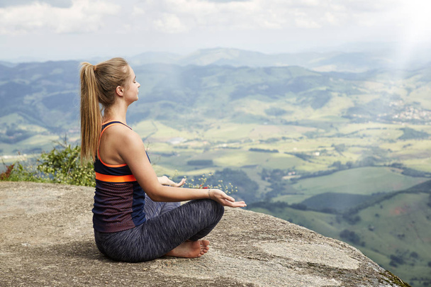 Beautiful woman meditating over landscape - Photo, Image