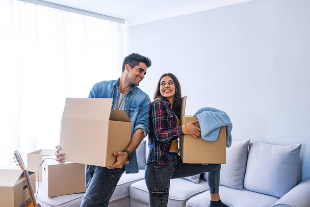 Young couple moving into new home with cardboard boxes  - Photo, Image
