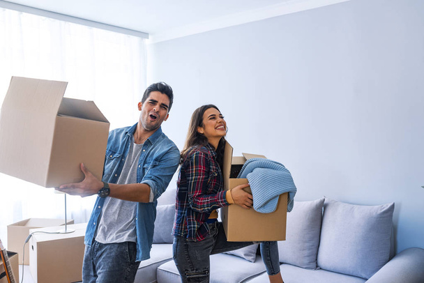 Young couple moving into new home with cardboard boxes  - Фото, изображение