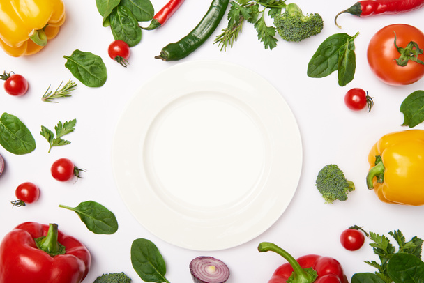 Flat lay with plate and natural vegetables on white background - Photo, Image
