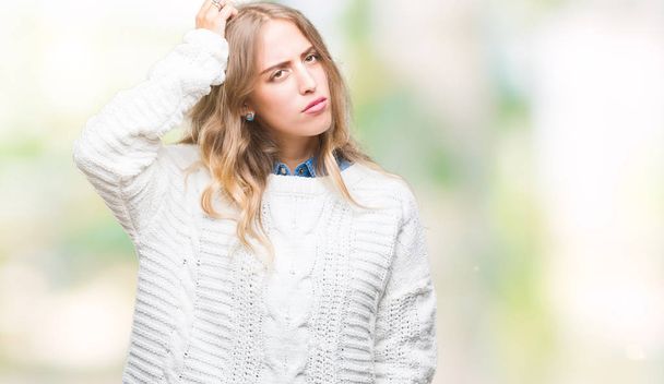 Beautiful young blonde woman wearing winter sweater over isolated background confuse and wonder about question. Uncertain with doubt, thinking with hand on head. Pensive concept. - Foto, imagen