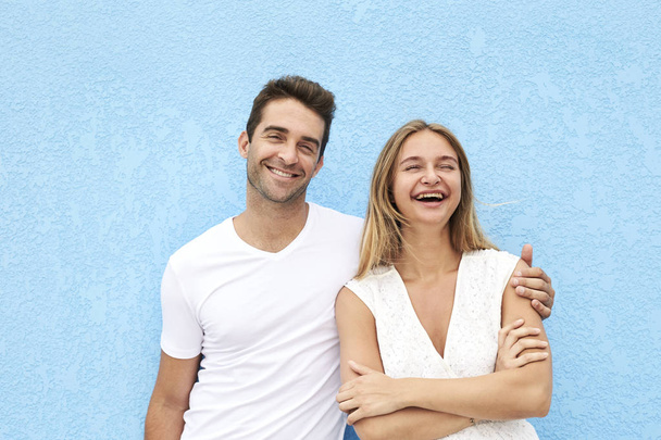 Couple smiling and laughing against blue background - Foto, Imagem