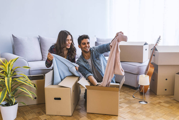 Young couple moving into new home with cardboard boxes  - Foto, Imagen