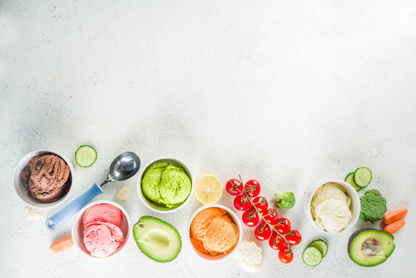 Модная веганская еда, летняя концепция здорового десерта, красочное диетическое овощное мороженое с авокадо, огурцом, помидорами, свеклой, морковью, брокколи, цветной капустой. Замороженный вегетарианский смузи, белый фон
 - Фото, изображение