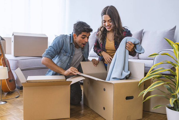 Young couple moving into new home with cardboard boxes  - Φωτογραφία, εικόνα