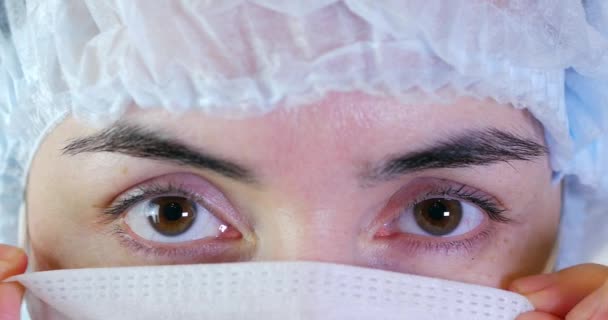 Πορτρέτο του ένα κοντινό πλάνο γυναίκα χειρουργός, ο γιατρός με μάσκα έτοιμο για λειτουργία σε νοσοκομείο ή κλινική. Οι γιατροί τα μάτια - Πλάνα, βίντεο