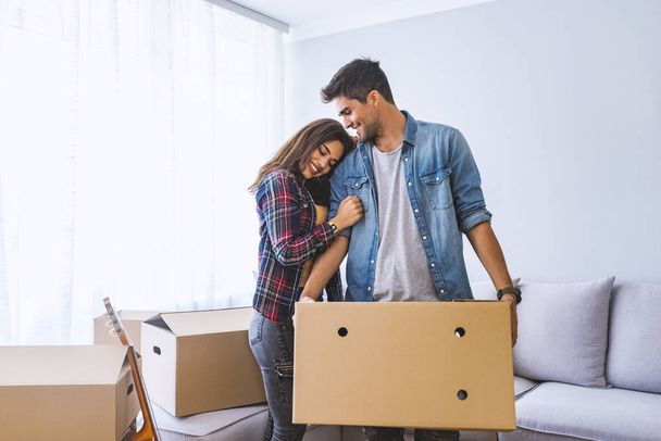 Young couple moving into new home with cardboard boxes  - Zdjęcie, obraz