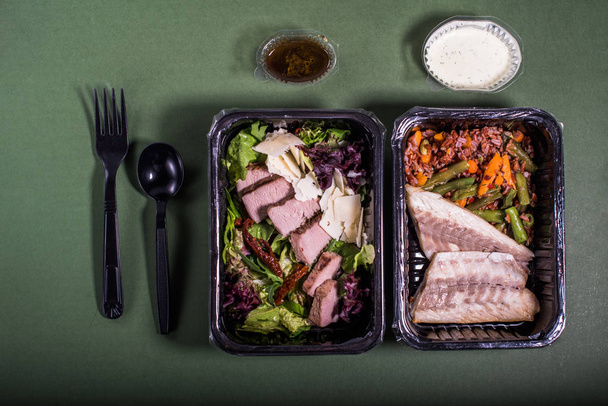 groente salades met vlees en vis in plastic containers op een grijze achtergrond - Foto, afbeelding