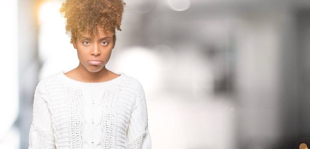 Όμορφη νεαρή αφρικανική αμερικανική γυναίκα φορώντας χειμώνα πουλόβερ πέρα από το απομονωμένο υπόβαθρο κατάθλιψη και ανησυχία για την αγωνία, κλάμα, θυμωμένος και φοβισμένος. Θλιβερή έκφραση. - Φωτογραφία, εικόνα