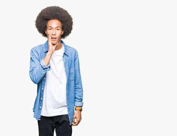 Giovane uomo afro-americano con i capelli afro mano sulla bocca raccontando voci segrete, sussurrando conversazione maliziosa
 - Foto, immagini