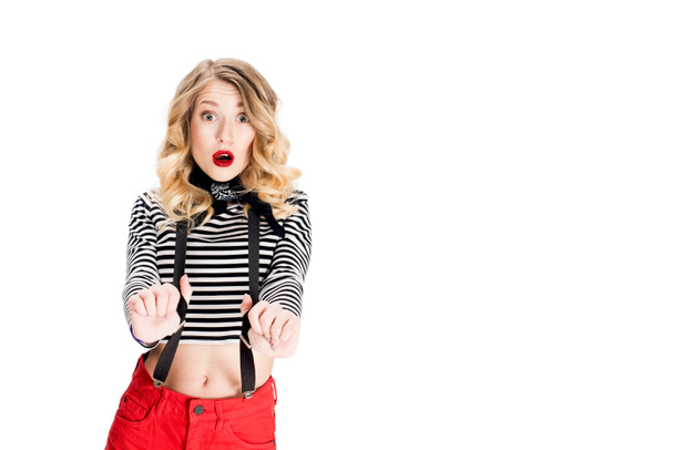 surprised blonde woman holding suspenders isolated on white - 写真・画像