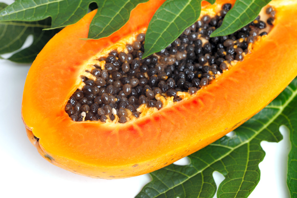 ώριμο papaya με σπόρους και πράσινο φύλλο απομονωμένη σε ένα λευκό έκφραση - Φωτογραφία, εικόνα