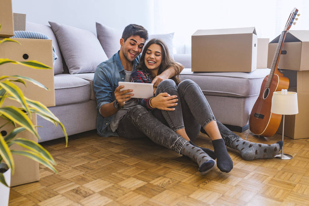 Young couple using digital tablet in new home  - Φωτογραφία, εικόνα