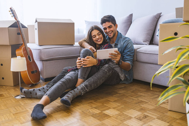 Young couple using digital tablet in new home  - Φωτογραφία, εικόνα